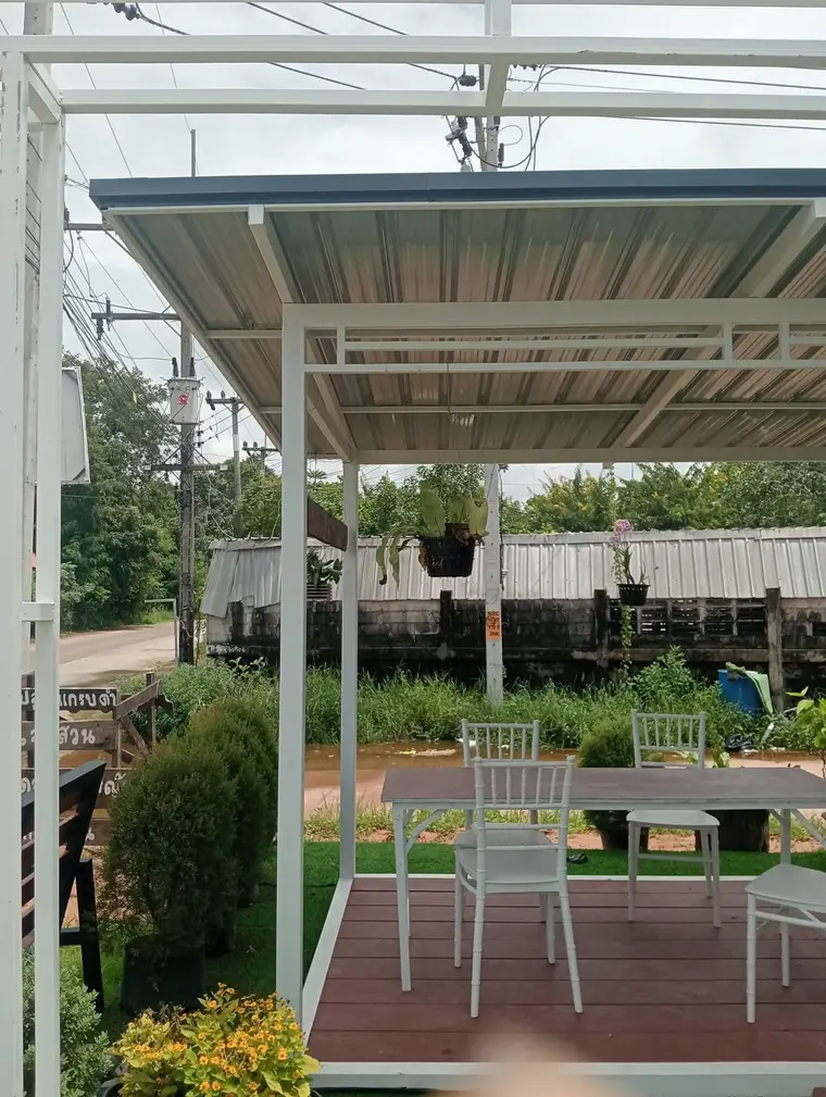 ซุ้มนั่งเล่นโครงเหล็กสีขาว หลังคาเมทัลชีท พื้นไม้เทียม ในสวน โคราช